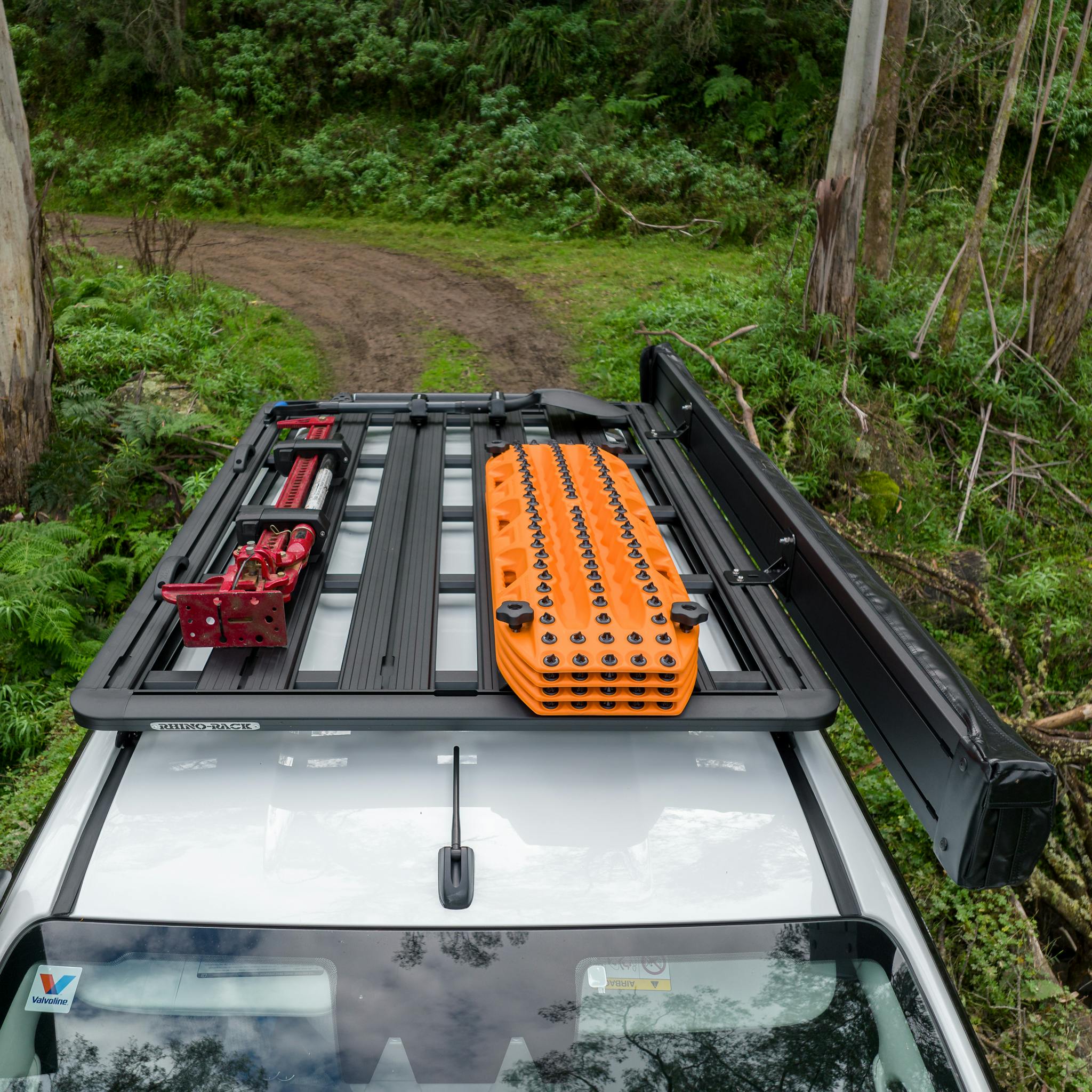maxtrax signature orange recovery board on suv driving down dirt road