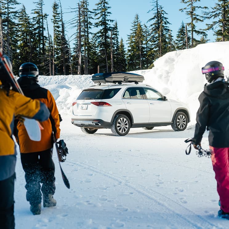 Yakima CBX cargo box on white SUV parked in front of snowbank