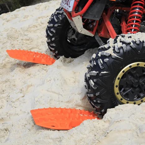Maxtrax Mini Recovery boards under UTV tires in desert