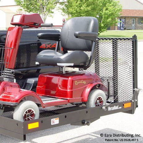 Versahaul mobility scooter carrier installed on back of truck with ramp up loaded with scooter side view