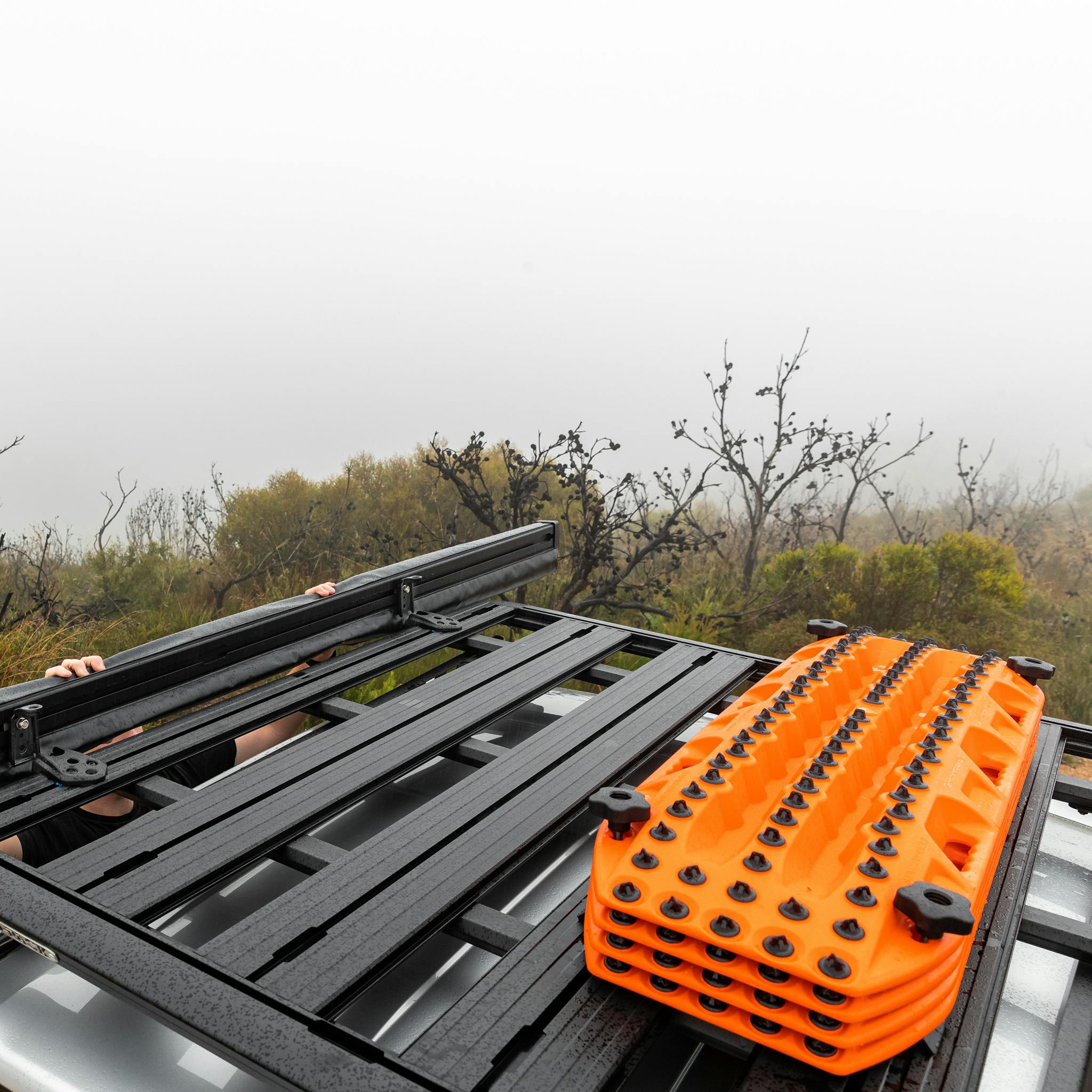 Maxtrax signature orange recovery board on top of SUV