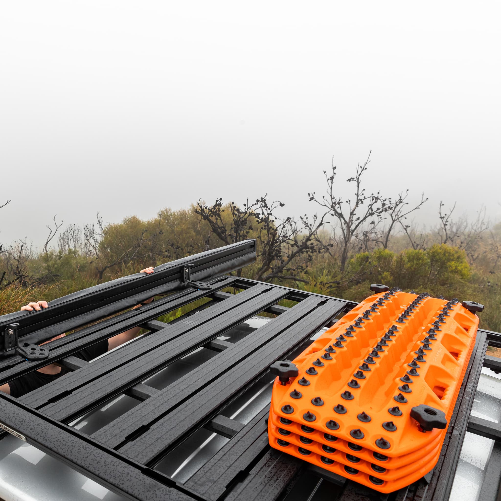 Maxtrax signature orange recovery board on top of SUV