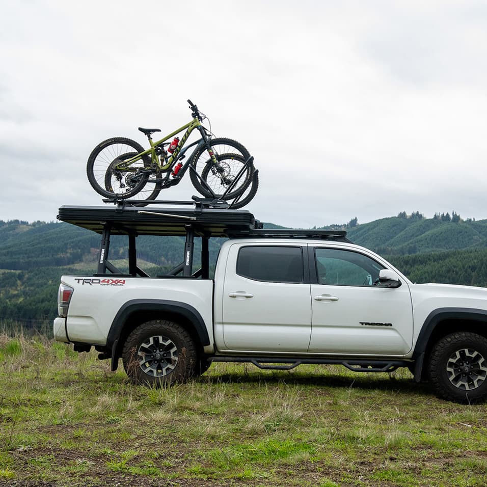 lifestyle pic of skypeak hd tent installed with skypeak crossbars with bike on top