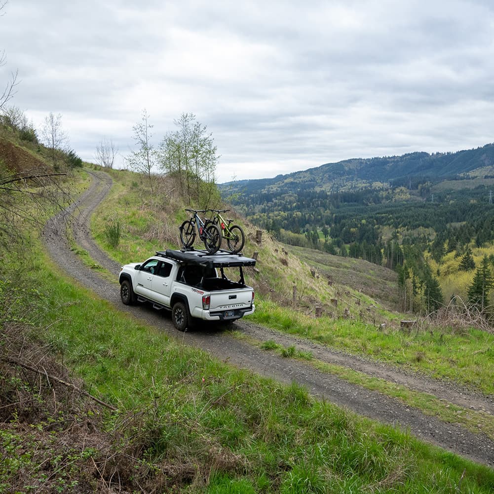 lifestyle pic of truck offroading with skypeak hd tent folded down on ladder rack