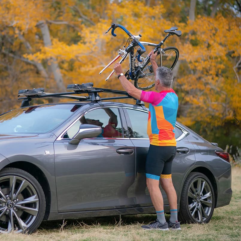 Yakima highspeed on roof of vehicle in nature with biker loading bike onit