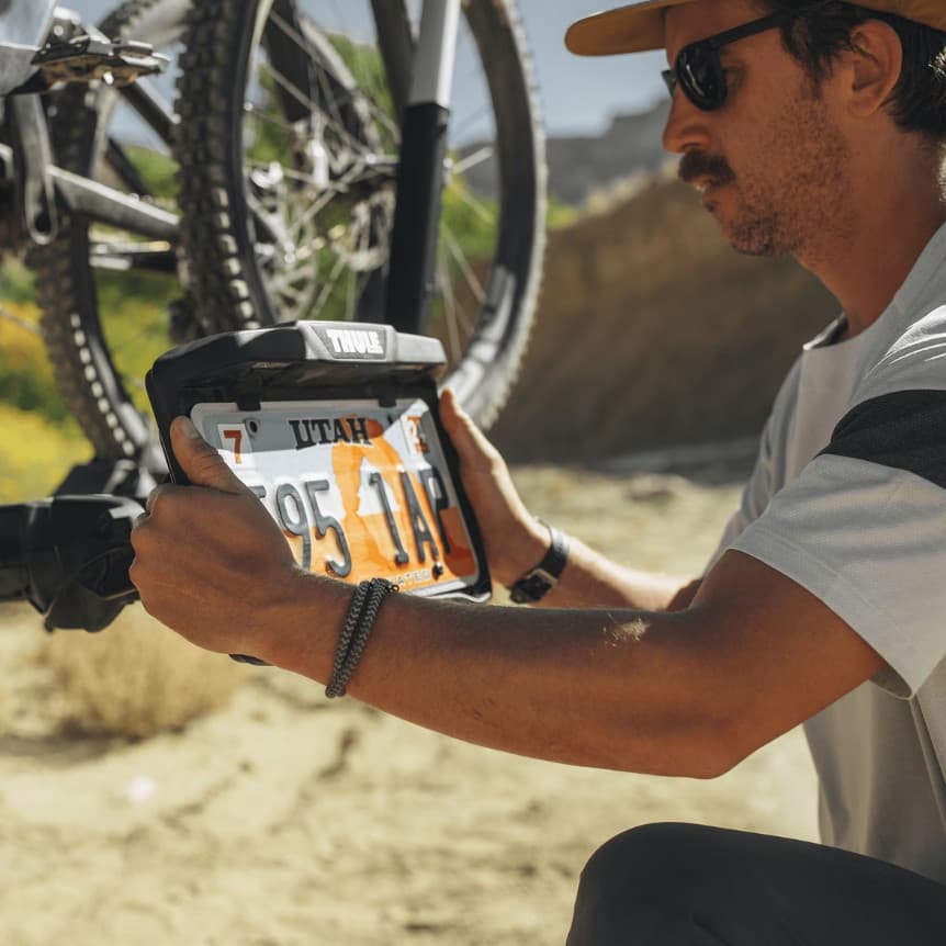 Close up of man putting the license plate on the bike rack in nature