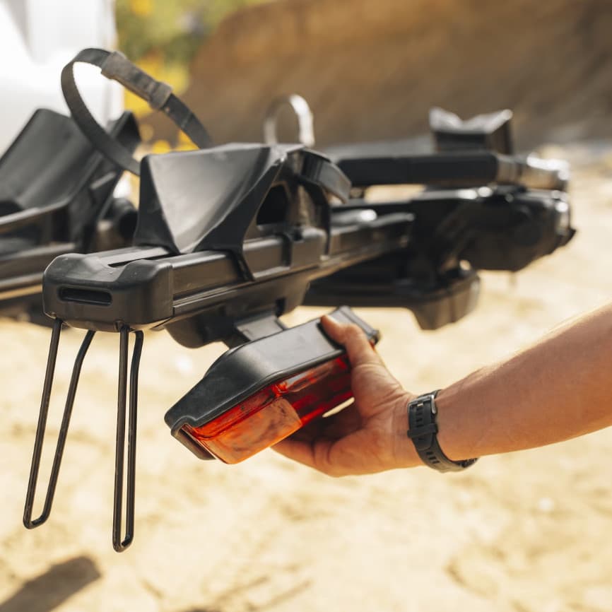 Close up of a mans hand installing the lighting fixture on the bike rack in nature