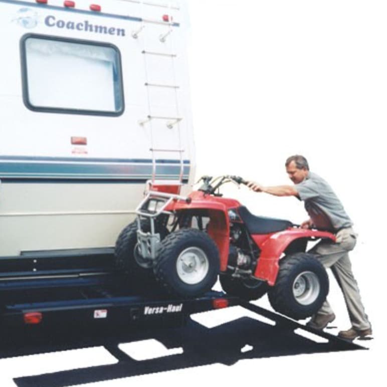 man pushing atv up on the versahaul atv and ramp it installed on rv motorhome