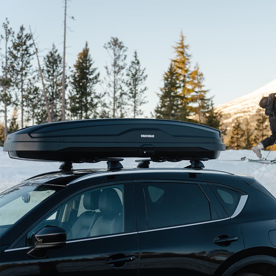 side profile of Yakima NX Skinny Cargo box installed on SUV in nature