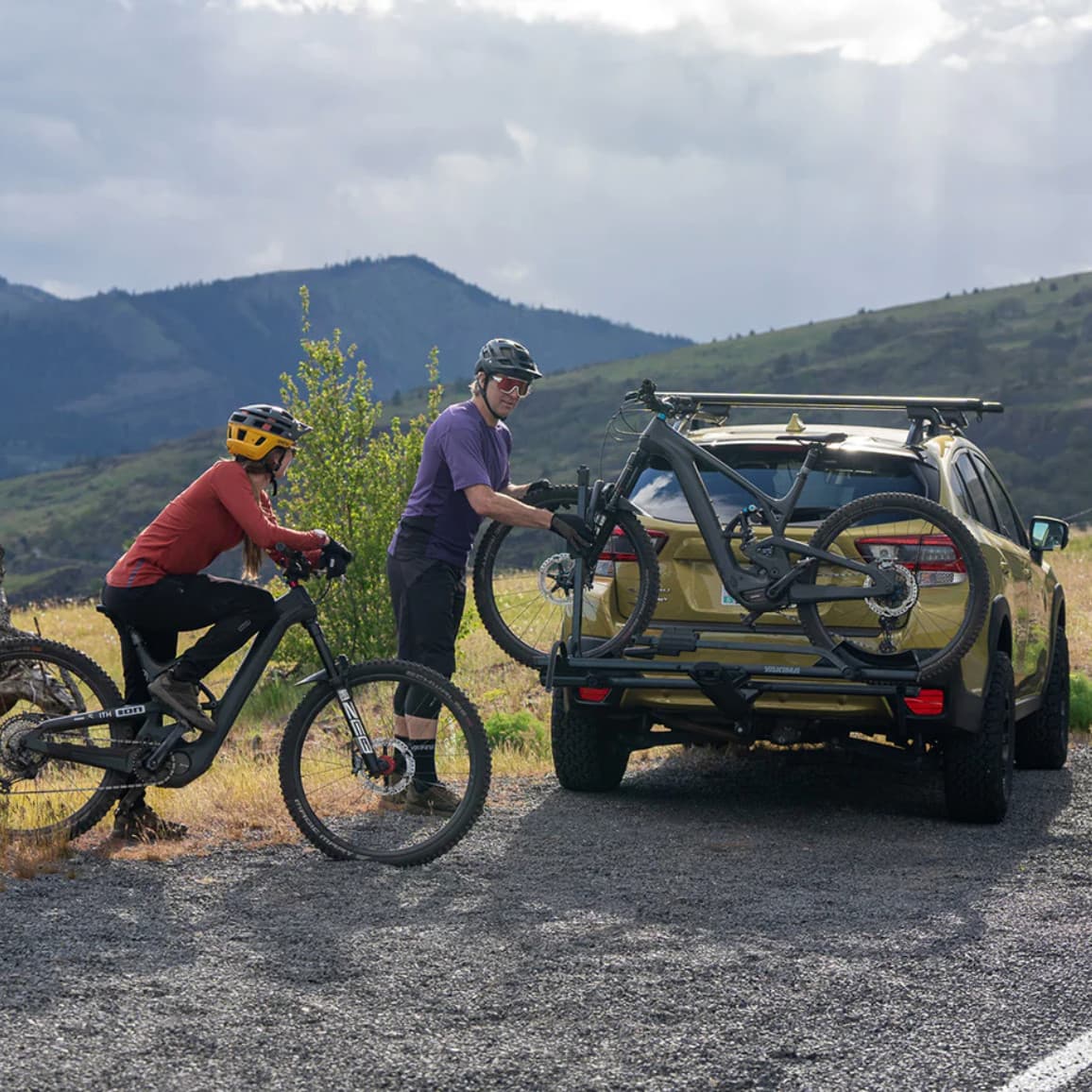 Lifestyle photo of man on bike riding up to the StageTwo on the back of vehicle in nature
